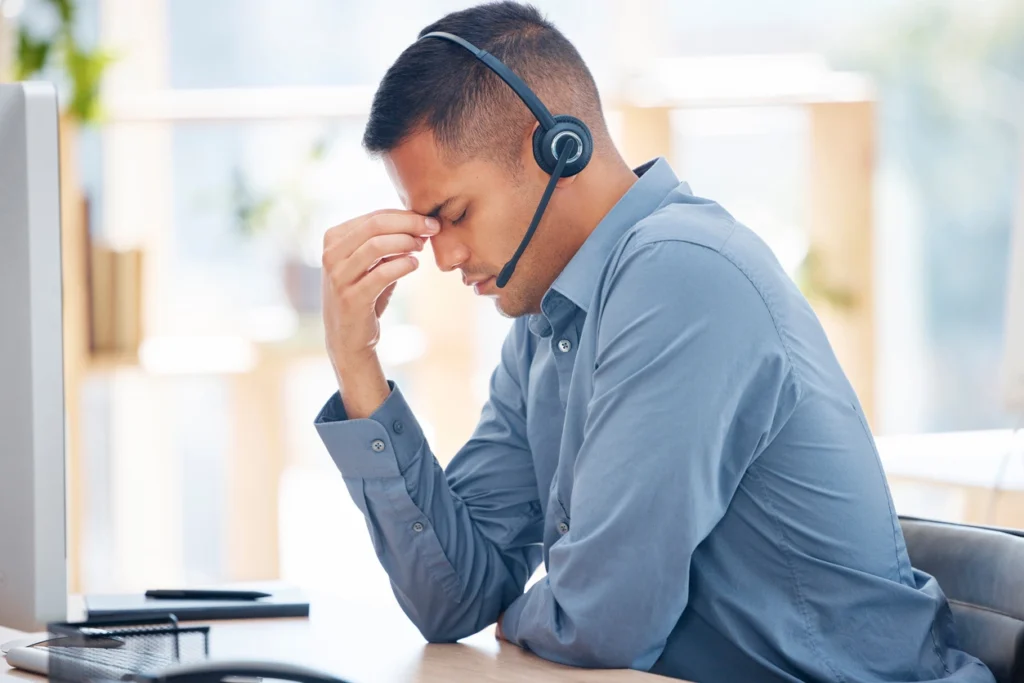 a stressed man wearing a headset with a microphone